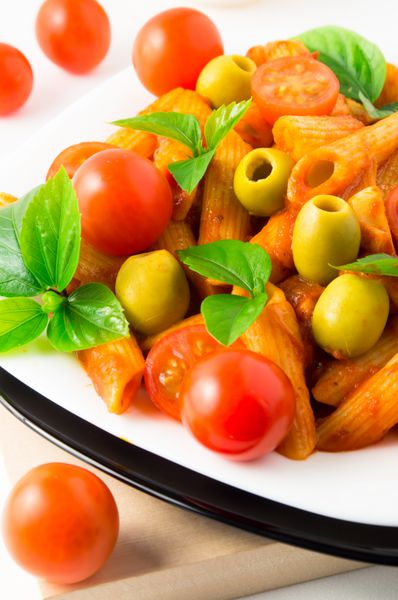 جزئیات یک بشقاب نزدیک پنه پاستا ایتالیایی با سس گوجه فرنگی