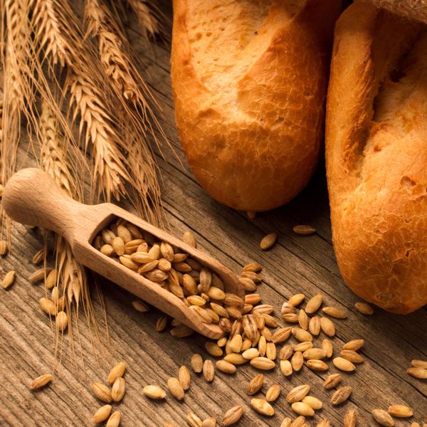 قاشق با دانه نان و نان روی میز چوبی