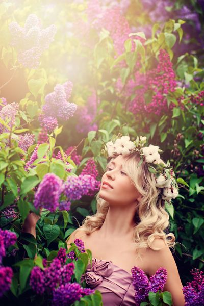 زن بلوند کامل با موهای مجعد و تاج گل در نور خورشید