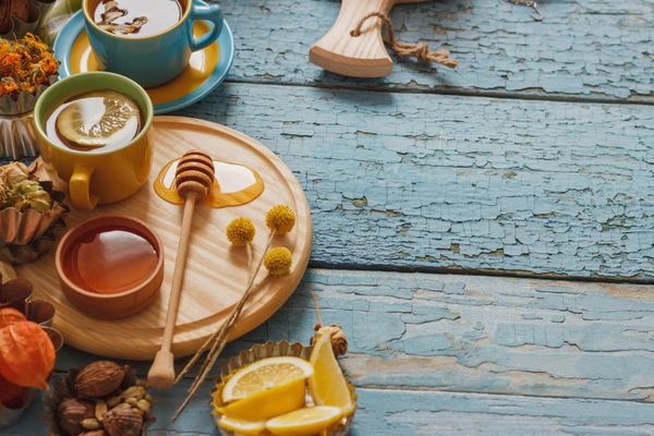 فنجان با چای گیاهی و تکه های لیمو سبزی خشک و تزئینات مختلف