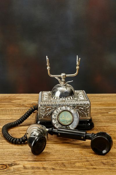 تلفن قدیمی روی میز چوبی