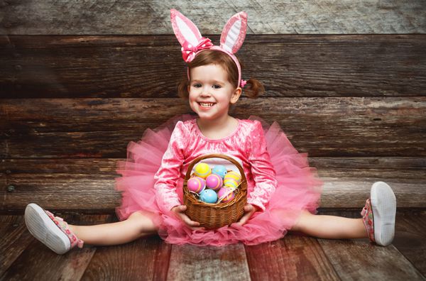 دختر بچه فانی شاد در لباس اسم حیوان دست اموز عید پاک با تخم مرغ