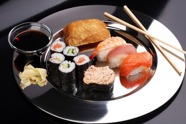 کلوزآپ ست سوشی ساشیمی با چاپستیک و سویا - رول سوشی با ماهی سالمون و رول سوشی ماکی و نیگیری خوشمزه