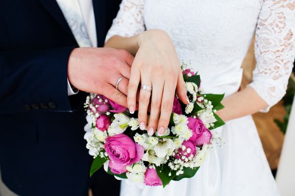 دست با حلقه ازدواج و دسته گل عروس