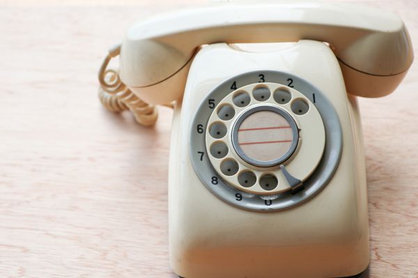 تلفن آنتیک به سبک قدیمی روی میز چوبی