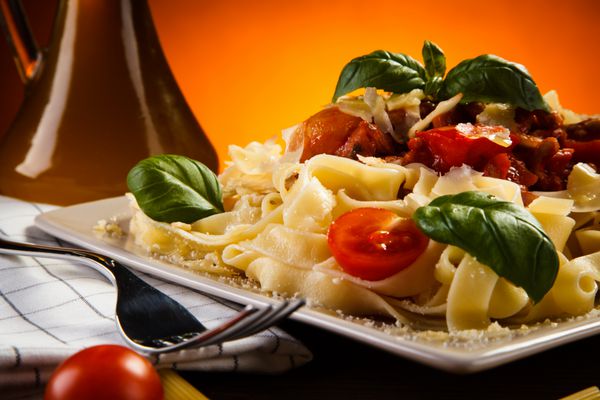 پاستا با سس گوجه فرنگی و سبزیجات روی میز
