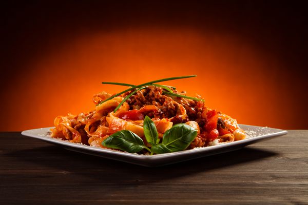 پاستا با سس گوجه فرنگی و سبزیجات روی میز