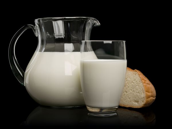 تکه نان سفید و ظروف شیشه ای پر از شیر