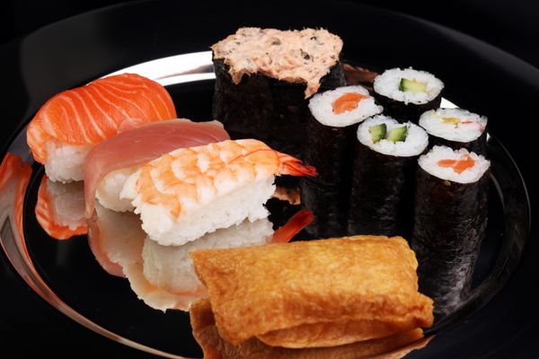 کلوزآپ ست سوشی ساشیمی با چاپستیک و سویا - رول سوشی با ماهی سالمون و رول سوشی ماکی و نیگیری خوشمزه
