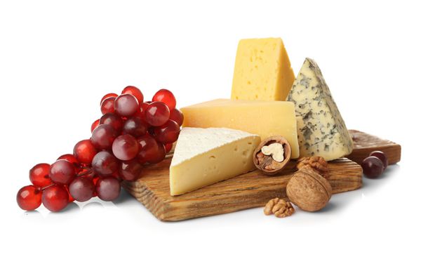 تخته با مجموعه ای از پنیر خوشمزه انگور و آجیل در زمینه سفید