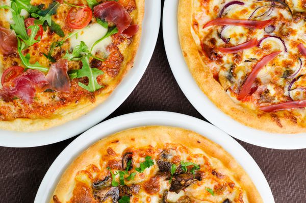 سه نوع مختلف پیتزای خوشمزه که از نمای نزدیک گرفته شده است