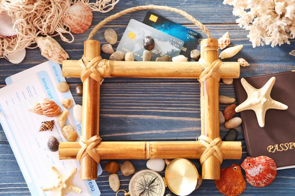 مفهوم سفر ترکیب نمادهای دریایی و قاب بامبو خالی در زمینه چوبی آبی