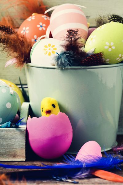 تخم مرغ های عید پاک پرها و جوجه اسباب بازی تزئین شده است