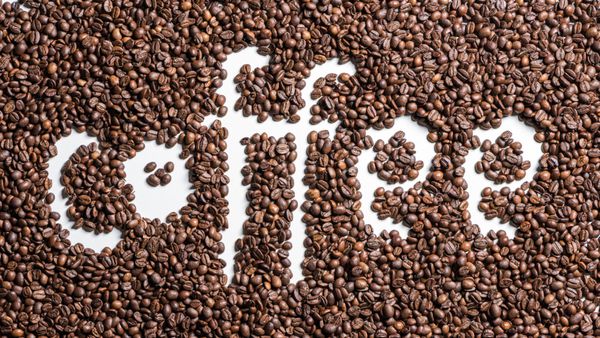 نمای بالای قهوه کلمه ساخته شده از دانه های قهوه برشته شده