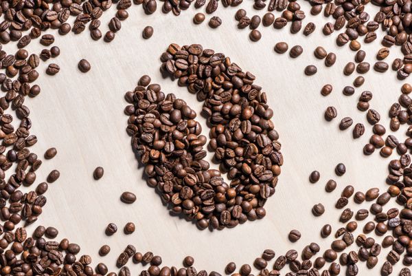 نمای نزدیک نماد دانه قهوه از دانه‌های قهوه بو داده روی میز