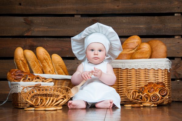 کودک در پس زمینه سبدهایی با رول و نان کروسان می پزد