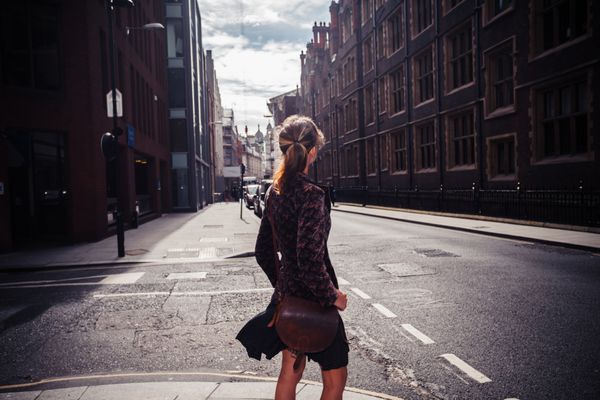 زن جوان در حال قدم زدن در خیابان