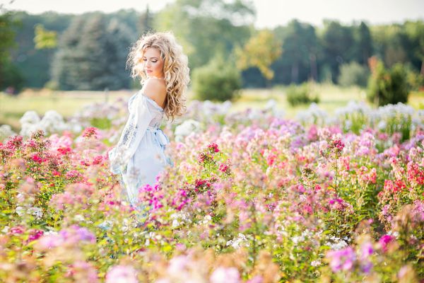 دختر جوان زیبا در باغ گل