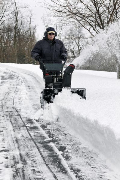 مردی در حال پاکسازی مسیر برف