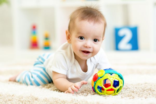 پسر بچه در حال بازی با اسباب بازی در داخل خانه