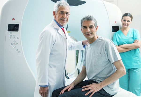 مردی در 40 سالگی آماده انجام اسکن MRI با کمک دو خندان است