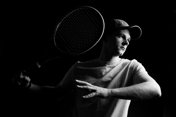 بازیکن تنیس در پس زمینه مشکی شات استودیویی