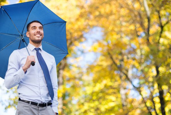 تاجر با چتر بر روی پس زمینه پاییز