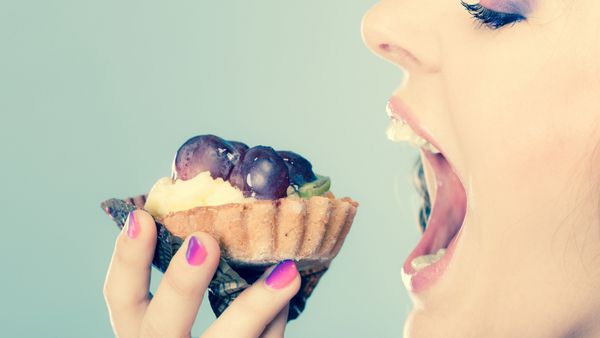 پروفایل صورت زن دهان باز در حال خوردن کیک