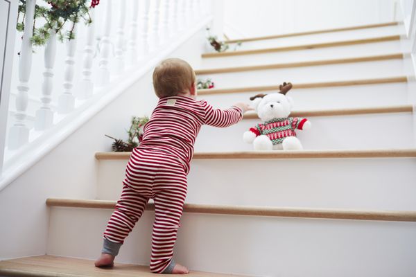 دختر جوان روی پله ها با لباس خواب در کریسمس