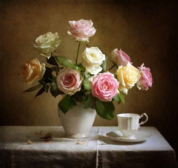 طبیعت بی جان با گل های رز زیبا و یک فنجان چای