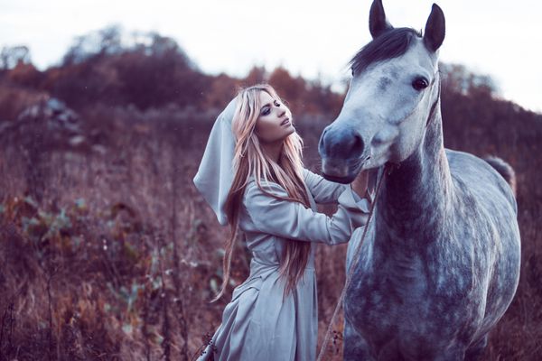 بلوندی زیبایی با اسب در مزرعه اثر تونینگ