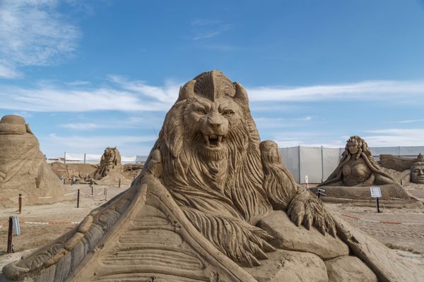 آنتالیا ترکیه - 23 آوریل 2016 نمایی از مجسمه بزرگ شنی از شخصیت های اساطیری ساخته شده در ساحل لارا آنتالیا برای پروژه زمین شنی در پس زمینه آسمان آبی ابری