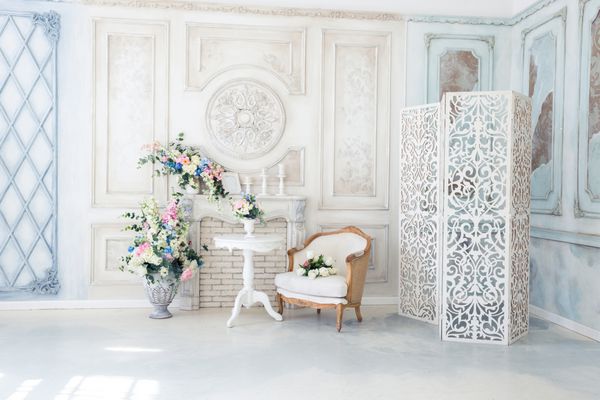 اتاق نشیمن داخلی با رنگ سفید و آبی لوکس روشن با گل در گلدان دیوارها با تزئینات باروک تزئین شده است