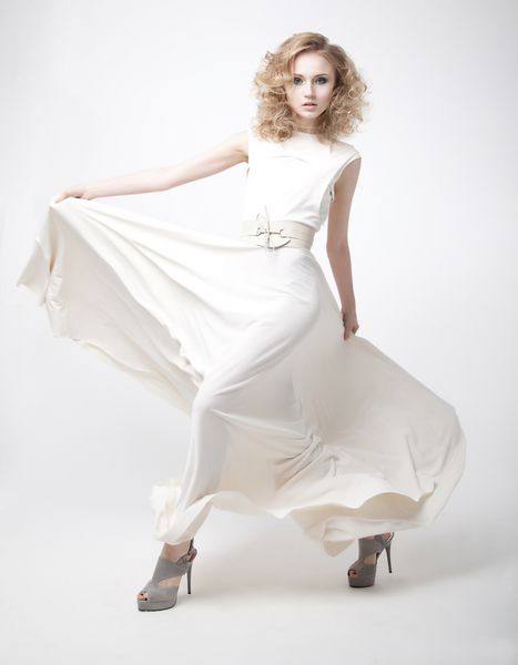 زن جوان زیبا با لباس عاج پرنده ایزوله شده روی پس زمینه سفید