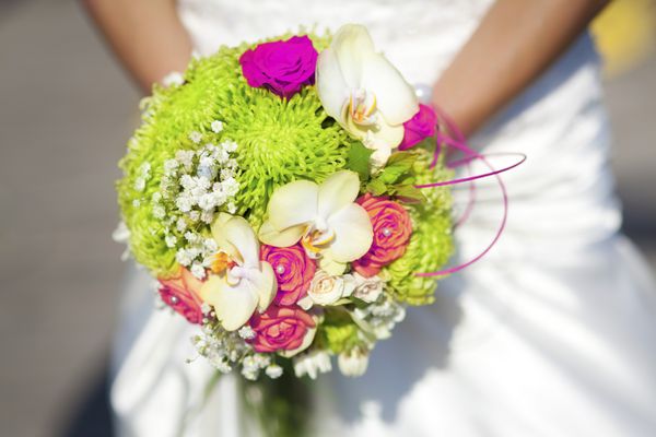 دسته گل عروسی در دستان عروس - زنی با لباس سفید که گل های رنگارنگ عروسی تازه را در دست دارد تزیین عروس شیک و کلاسیک با ارکیده های کرم رنگ شگفت انگیز و رز صورتی برای ازدواج