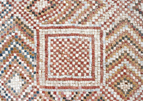 تکه ای از موزاییک کف باستانی کاشی های کوچک رنگارنگ تزئینات هندسی غیرمعمول فرم های گلدار و منظم