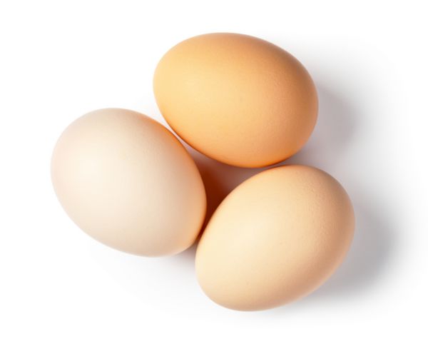 سه تخم مرغ در پس زمینه سفید نمای بالا