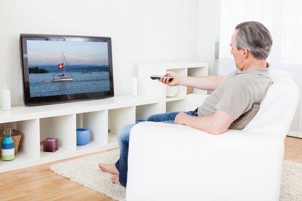 پرتره مرد بالغ در حال تماشای تلویزیون در خانه