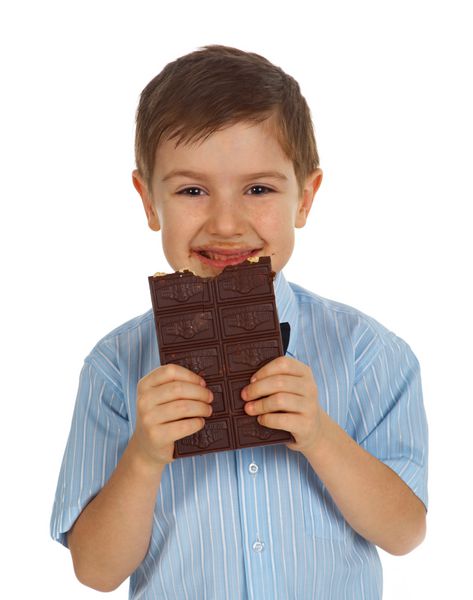بچه جوان بامزه خندان در حال خوردن شکلات سفید جدا شده