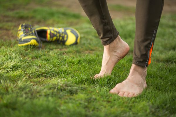 دونده مرد در حال استراحت پس از دویدن در فضای باز تمرین در پارک بهار روی پای راست تمرکز کنید