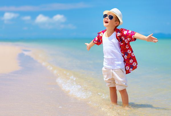 پسر خوش استایل از زندگی در ساحل تابستانی لذت می برد