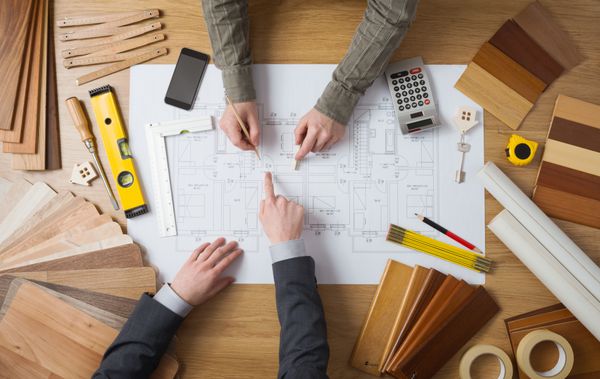 تاجر مشتری و مهندس ساخت و ساز با هم در یک پروژه ساختمانی نمای بالای دسکتاپ کار می کنند