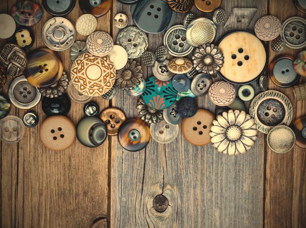 مجموعه ای از دکمه های مختلف قدیمی روی تابلوهای میز قدیمی با فضای کپی نزدیک سبک رترو تصویر اینستاگرام