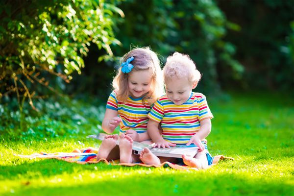 بچه ها در حال خواندن کتاب در باغ تابستانی بچه ها درس می خوانند دختر و پسر در حیاط مدرسه بازی می کنند دوستان پیش دبستانی و یادگیری خواهر و برادر در حال انجام تکالیف بچه مهدکودک و کودک نوپا کتاب می خوانند