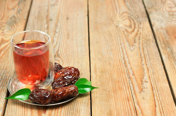 طبیعت بی جان غذا و نوشیدنی مفهوم تعطیلات خرما و چای ماه رمضان روی میز چوبی فوکوس انتخابی پس‌زمینه فضای کپی