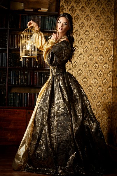 سبک رنسانس - زن جوان زیبا با لباس گران قیمت سرسبز در فضای داخلی قصر قدیمی سبک وینتیج روش