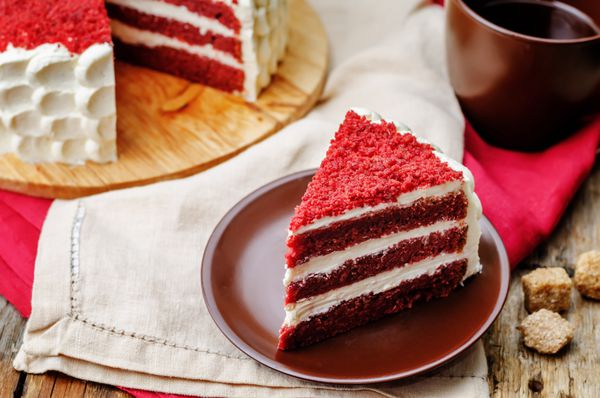 کیک قرمز مخملی در زمینه چوب تیره تونینگ تمرکز انتخابی