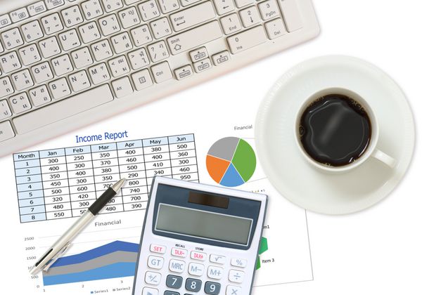 گزارش تجاری و مالی با خودکار و ماشین حساب روی میز در دفتر