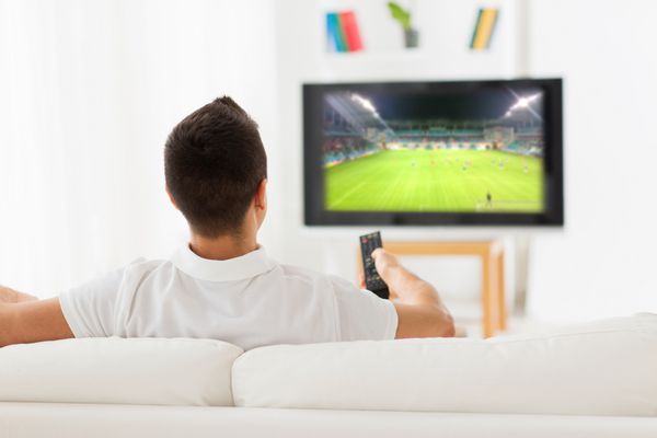 اوقات فراغت فناوری رسانه ورزش و مفهوم مردم - مردی که از پشت در خانه در حال تماشای بازی فوتبال در تلویزیون در خانه است