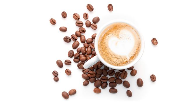 فنجان کوچک کاپوچینو با دانه‌های قهوه و فوم شیر شکل قلب نمای بالا جدا شده در پس‌زمینه سفید